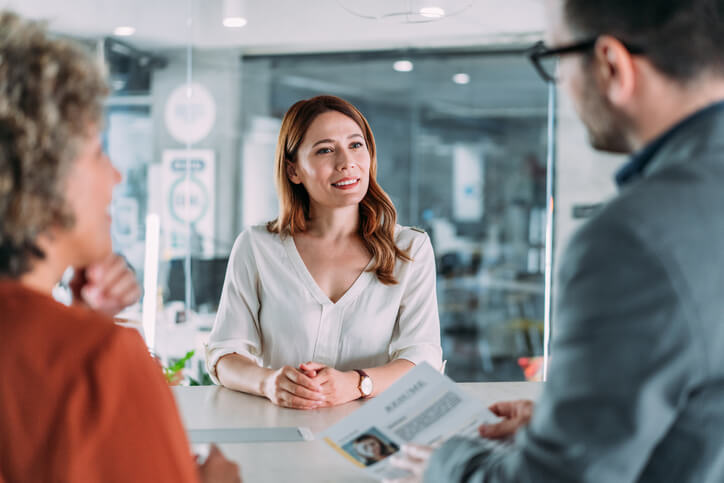 Shot of a male recruiter interview female candidate. Applicant presenting her resume to director while sitting with him at table during job interview. Male employer accepting resume from an applicant.
